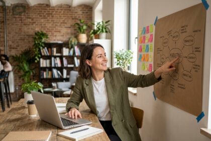 Entrepreneuse travaillant sur une stratégie de communication à petit budget dans un espace de coworking chaleureux